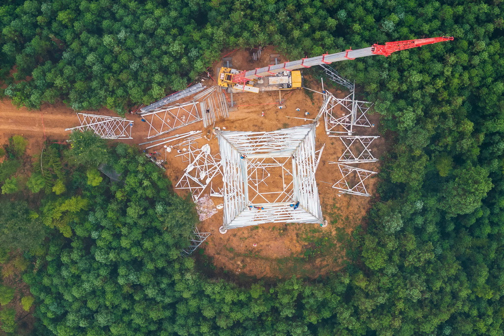 9月16日，在位于常德市桃源县的“宁电入湘”工程沅江跨越施工现场，电力工人在进行组塔作业（无人机照片）。