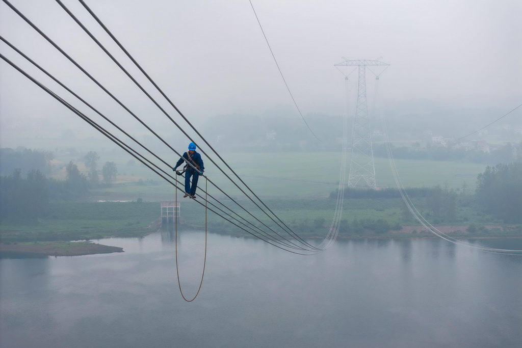 9月16日，在位于常德市桃源县的“宁电入湘”工程沅江跨越施工现场，电力工人在进行附件安装准备工作（无人机照片）。