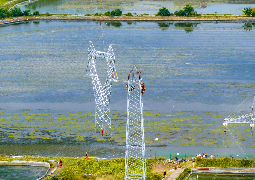 9月24日，直升机在江苏省兴化市昌荣镇上空协助铁塔架设作业（无人机照片）。新华社发（周社根摄）