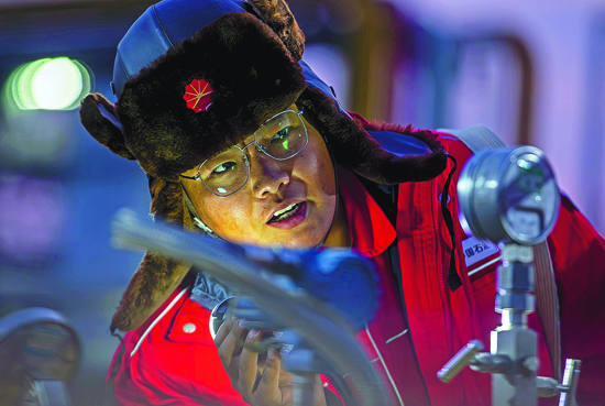 负责设备管理的新员工王国彪在南疆利民工程外输装置区通过压力变化，检查新设备的运行情况。