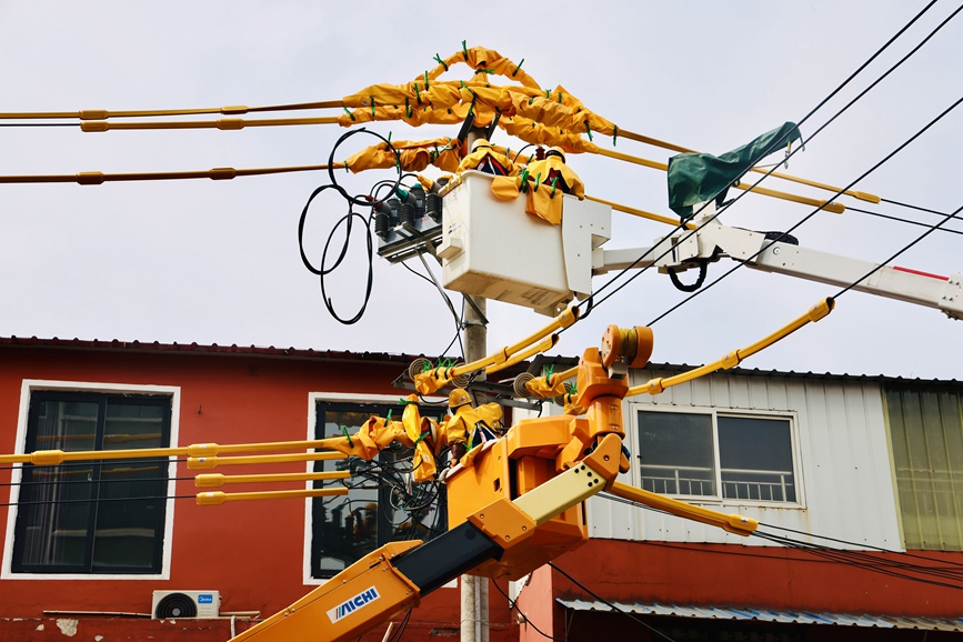 河南洛阳孟津供电公司带电作业人员在10千伏麻水线开展带电加装柱上开关作业。刘伟韬 摄