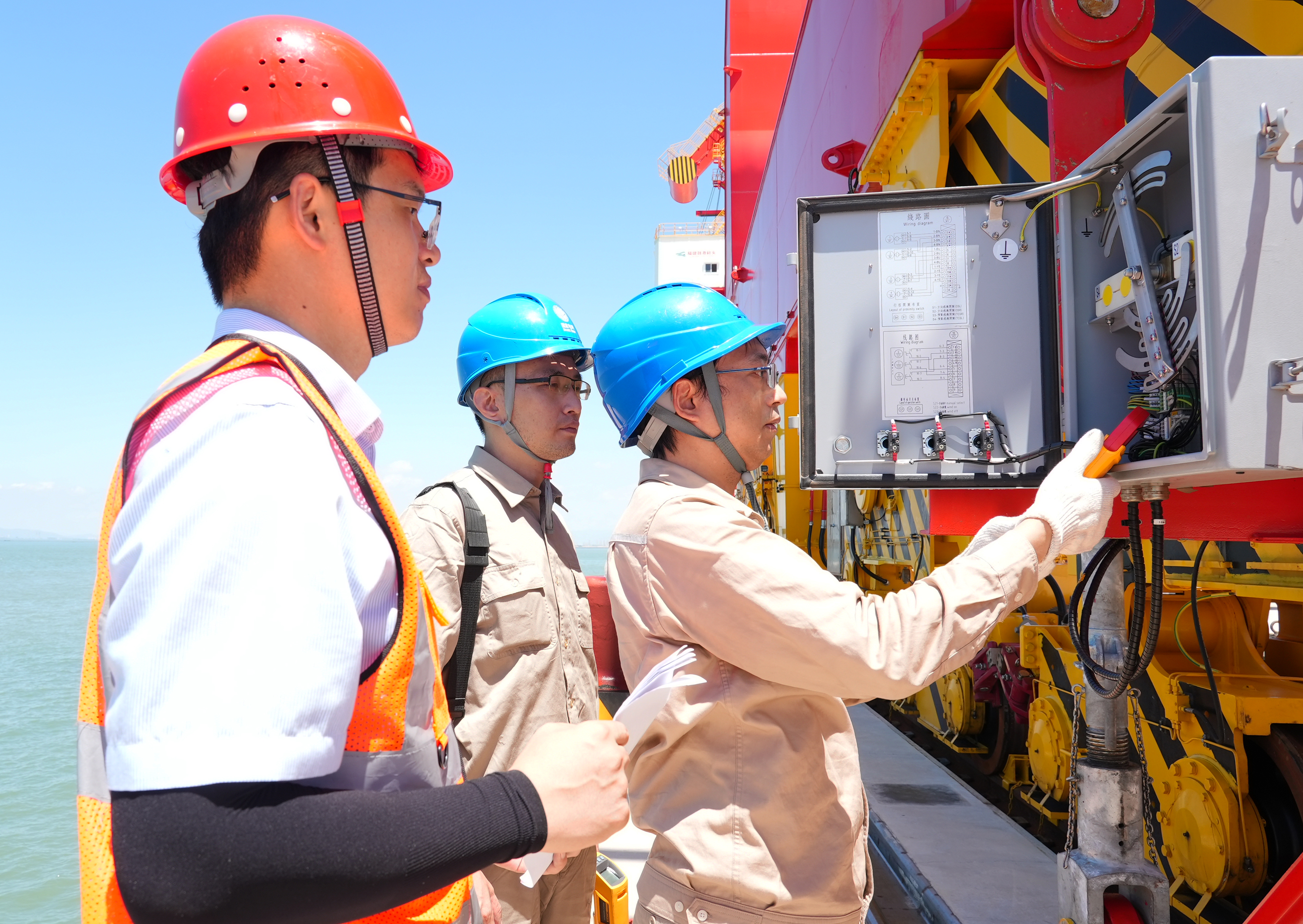 7月3日福建福州供电公司员工林森和钱骅冒着40℃的高温对福建省东北地区首个零排放全电动码头——融港码头的电动龙门吊的供电线路进行巡检（陈德钧）1.jpg
