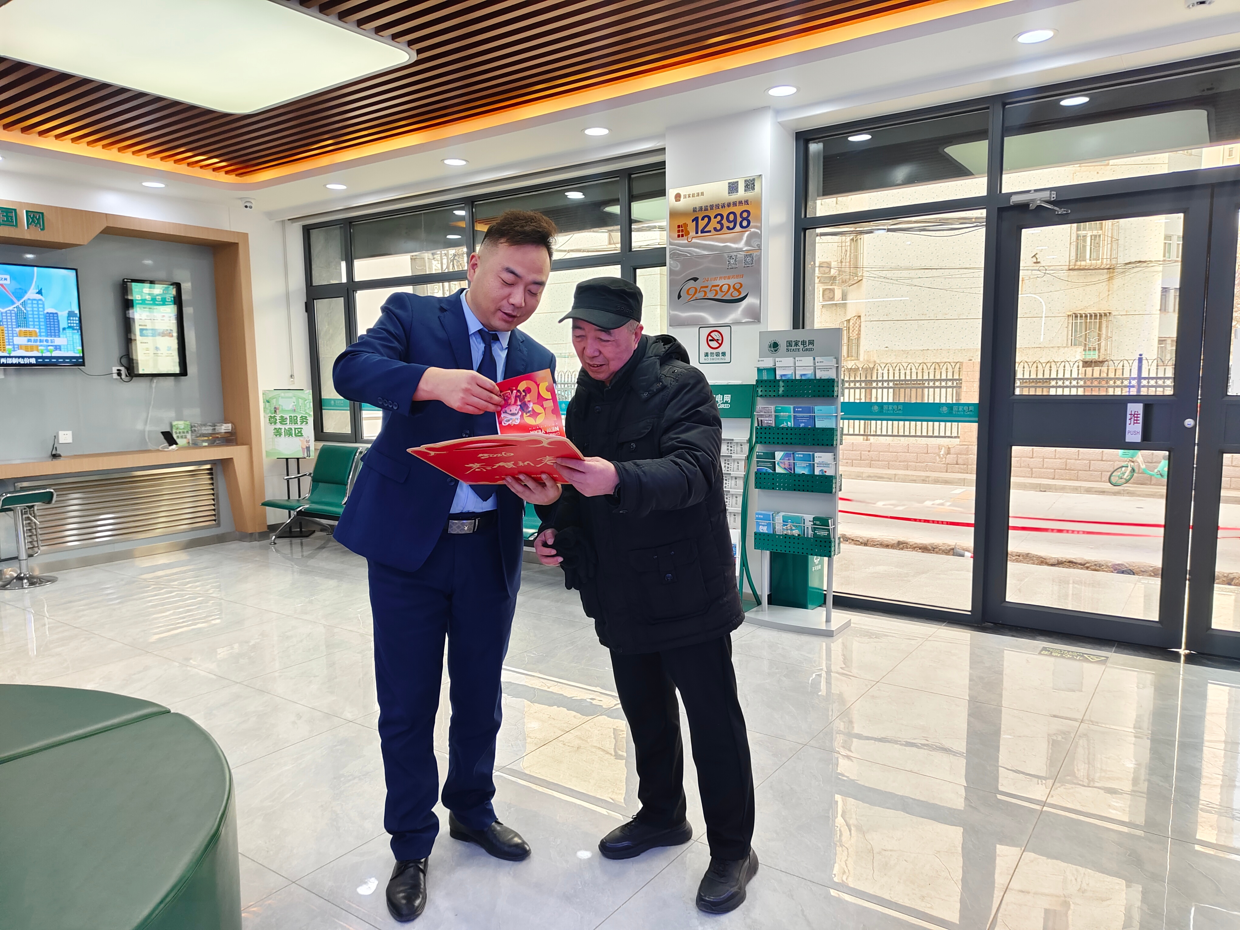 国网兰州供电公司员工在东岗供电营业厅向客户赠送定制<span class=